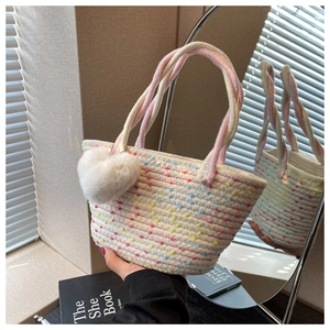 Detailaufnahme der handgewebten Tasche mit bunten Punkten und Plüsch-Herzanhänger