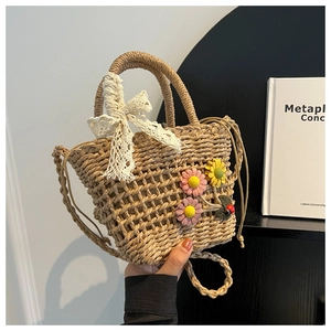 Detail of handmade woven straw bag featuring lace bows and colorful crochet flowers