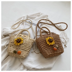 Detail of hand-woven straw bag with sunflower accents and colorful charms in soft lighting