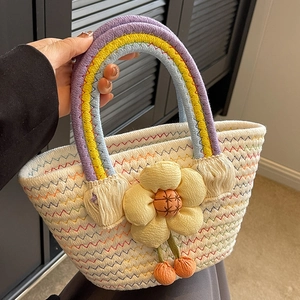 Fashionable woven straw tote bag with rainbow handles and 3D floral accent for summer travel