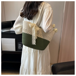 Détail du sac de plage tissé avec nœud en dentelle et design bicolore vert sur l'épaule