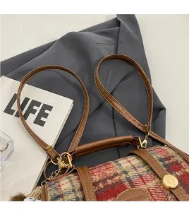Detailansicht der Retro-Tweed-Handtasche mit braunem Lederbesatz und verstellbarem Schultergurt