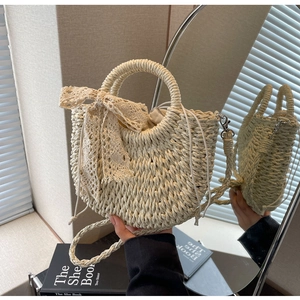 Detail of cream woven handbag featuring delicate lace bow and secure drawstring lining