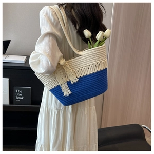 Détail du sac de plage tissé avec rayures bleues et un délicat nœud en dentelle beige