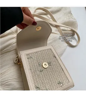 Détail du fermoir magnétique invisible sur le sac en paille brodé de feuilles vertes