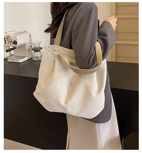 Minimalist tote bag detail showing the wide fabric strap and spacious side profile
