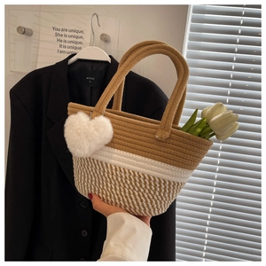 Detail der handgewebten Beuteltasche im zweifarbigen Design mit Plüschherz-Anhänger