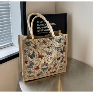 Détail du sac cabas en toile beige avec imprimés papillons colorés et fermoir aimanté