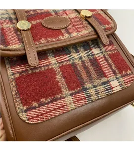 Makro-Detail von Karostoff-Struktur und Leder-Schnalle an einem Vintage-Rucksack