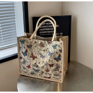 Détail du sac cabas bohème imprimé papillon avec anses en corde sur table en métal