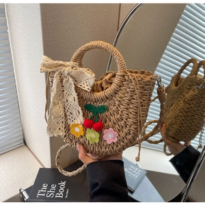 Detail of handmade straw bag with floral crochet, lace bow and drawstring inner liner