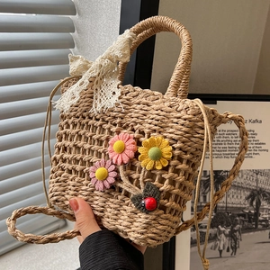 Handwoven straw beach bag with floral decor, lace bow, and drawstring closure for women