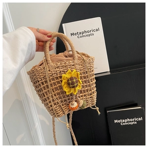Detail of hand-woven straw bag featuring a vibrant sunflower and drawstring inner lining