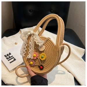 Detail der runden Strohtasche mit Spitzenschleife, Blumen und Seilgriffen