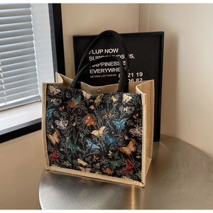 Gros plan d'un sac cabas en toile à motif papillon avec un fermoir en métal élégant