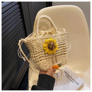 Close-up of handmade straw bag featuring a 3D sunflower and decorative pumpkin charms