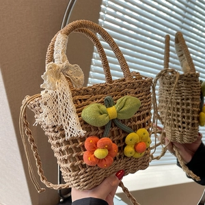 Handmade straw woven bag with white lace bow and crochet floral charms for summer vacation