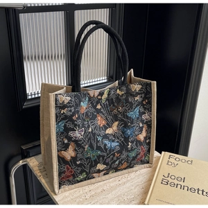 Détail d'un sac cabas imprimé papillon avec panneaux en jute naturelle et anses noires