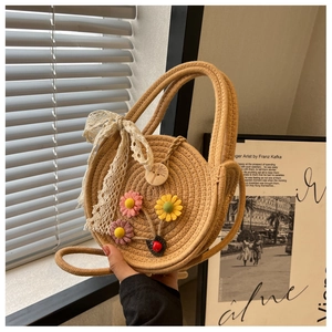 Detail der handgefertigten Strohtasche mit 3D-Blumenakzenten und zarter Spitzenschleife