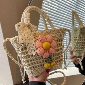 Handwoven straw shoulder bag in cream white with pink floral accent and lace bow details
