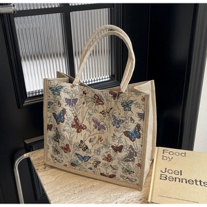 Détail d'un sac cabas en toile avec imprimé floral posé sur un support en marbre