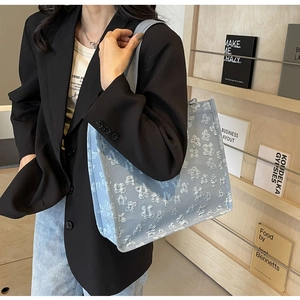 Close-up of light blue tote bag featuring premium 3D floral texture and wide fabric strap