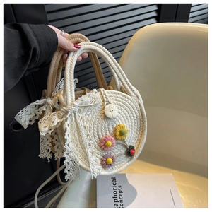 Detailaufnahme der runden handgewebten Tasche mit 3D-Blumen und Spitzenbesatz
