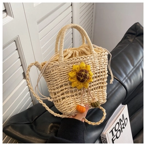 Detailed shot of hand-woven straw bag featuring sunflower decor and drawstring lining