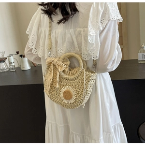 Detail of handmade straw bag featuring daisy flower and lace bow with drawstring closure