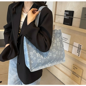 Detail of light blue canvas tote bag featuring 3D floral texture and wide straps