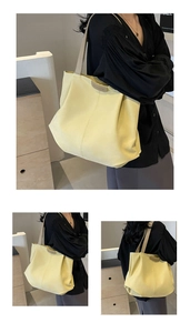 Detailed macro view of large yellow tote bag featuring fashion embossed leather patch detail