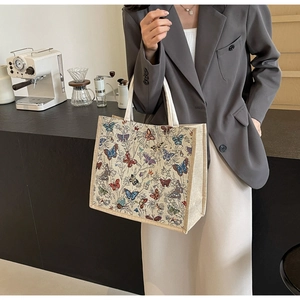 Détail d'un cabas vintage en tapisserie avec motifs papillons et textile beige