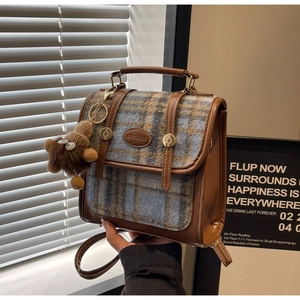 Details des Retro-Rucksacks aus karierter Wolle mit Lederbesatz und Plüschtier