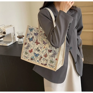 Gros plan détaillé d'un grand sac cabas avec broderies de papillons colorés sur toile de coton