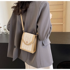 Detail of beige hand-woven crossbody bag with a herringbone flap and leather shoulder strap