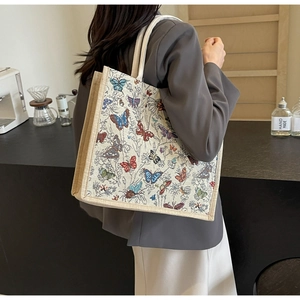 Détail du grand sac cabas en toile avec broderies papillons colorées et bandoulière large