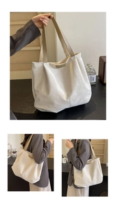 Detail of a large cream tote bag with brown straps and stylish fashion logo print