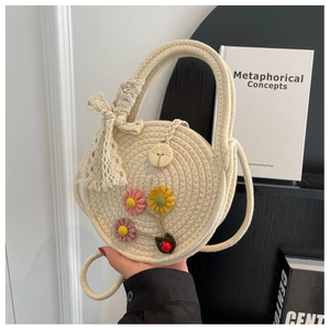 Detail einer handgewebten Strohtasche mit Blumenakzenten und rundem Holzknopf