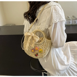 Detail view of woven straw basket bag with 3D flowers on white lace dress model