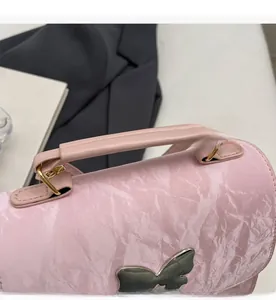 Détail du sac à main rose texture marbre avec une grande boucle papillon en métal poli
