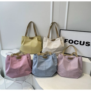 Detailed display of five colorful canvas tote bags in yellow, white, pink, blue, and purple