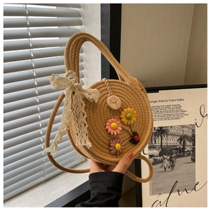 Detaillierte Makroansicht der Strohtasche mit 3D-Stoffblumen und Spitzen-Schleife