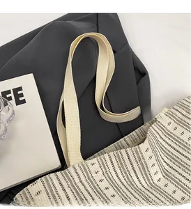 Detail of cream woven tote bag featuring high-density canvas handles and textured fabric