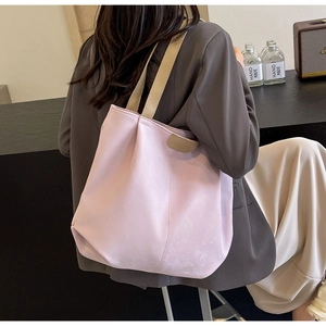 Close-up of pink tote bag showing the Fashion leather tag and woven shoulder strap