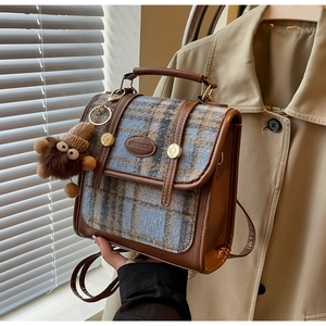 Detail des Vintage-Rucksacks mit Karomuster, Lederbesatz und einem süßen Plüsch-Anhänger