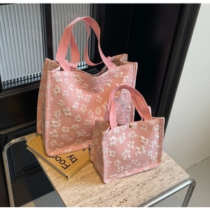 Detailed comparison of large and small pink canvas tote bags with white flower embroidery