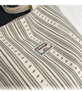 Close-up of thick corduroy tote bag texture with Nanaojie brand label and sturdy handles
