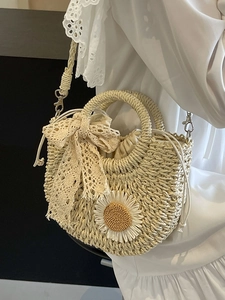 Handwoven cream straw crossbody bag with floral daisy and lace bow charms