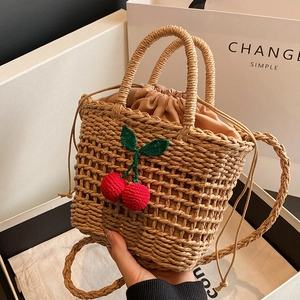Handmade woven straw bucket bag with red cherry crochet decor and drawstring liner