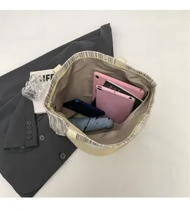 Top view of spacious corduroy tote bag interior holding a tablet, phone, and umbrella